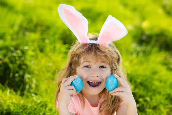 Felices fiestas de Pascua. Niño en orejas de conejo sostienen huevo de Pascua. Niño cazando huevo de Pascua. —  Fotos de Stock