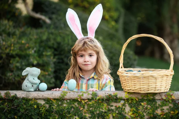 Kind met paaseieren in mand buiten. Fijne paasdag. Kind met konijnenoren. Paaseieren zoeken. Fynny kinderen portret. — Stockfoto