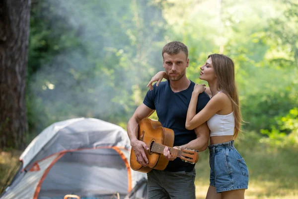 Romantisches Paar beim Zelten in der Frühlingslandschaft, Mann mit Gitarre. Abenteuer für junge Liebhaber Camper in der Natur. Wanderpaar verliebt. — Stockfoto