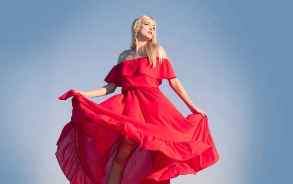 Vrouw in rode jurk beweging aan de hemel. Modieus jong model in stijl jurk. Fashion vrouw in de zomer. — Stockfoto