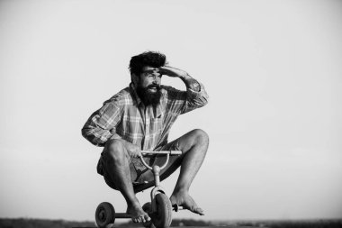 Küçük bir bisiklet süren çılgın bir adam. Çocuk bisikleti süren komik adam..