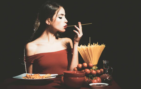 Mooie jonge vrouw met noedels spaghetti, sexy keuken. — Stockfoto