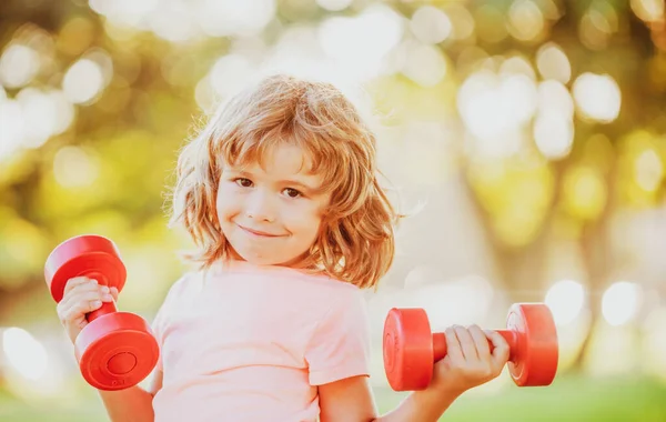 Dambılı bir çocuk. Çocuklar spor yapar. Çocuk parkta egzersiz yapıyor. Aktif, sağlıklı yaşam tarzı. — Stok fotoğraf