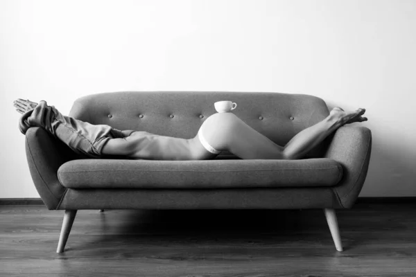Mulher sexy com xícara de café no sofá. Torso nu, café conceito manhã. — Fotografia de Stock