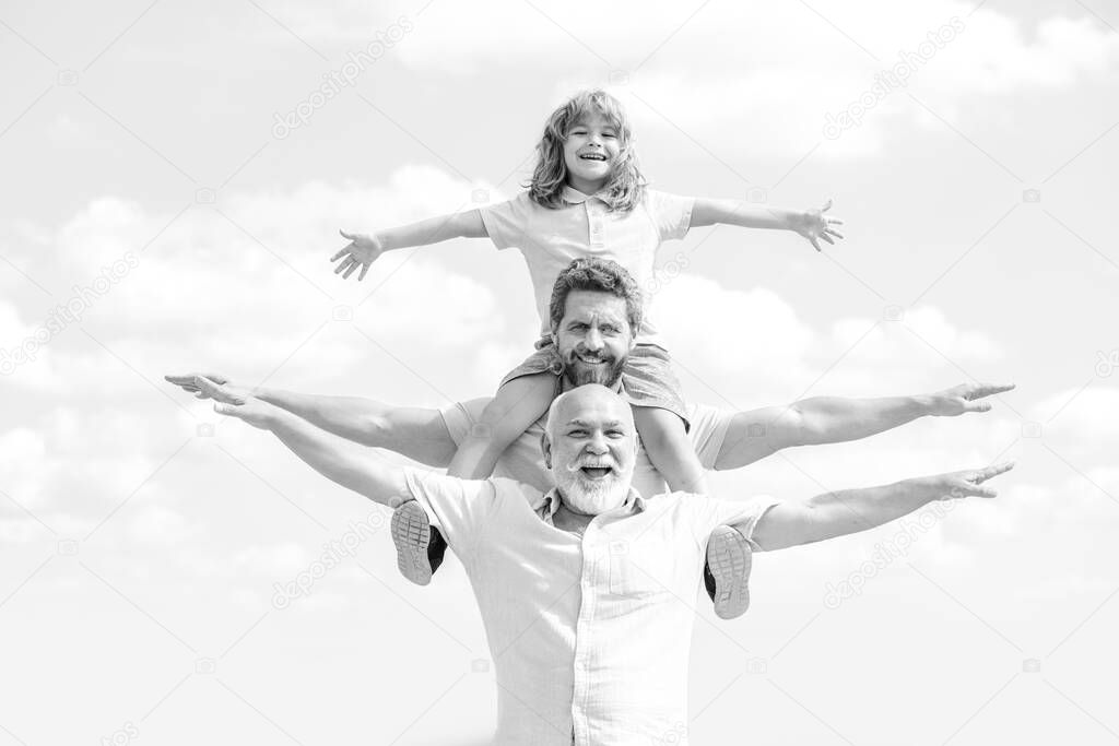 Fathers day. Father and son with grandfather raising hands or open arms flying. Men generation.