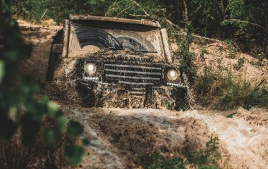 Dağ yolunda off-road seyahat. Çamur ve su sıçratıyor. Hareket tekerlekler lastikleri ve off-road toz gider.