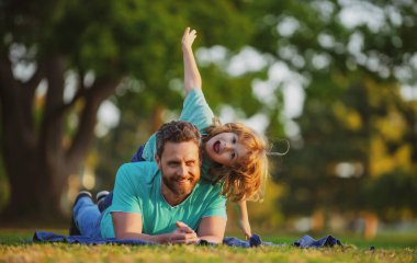 Baba ve oğlu yazın açık hava parkında oynuyorlar. Hafta sonu aktivitesi mutlu aile hayatı konsepti. Sağlıklı tatil ve aile aktivitesi kavramı.