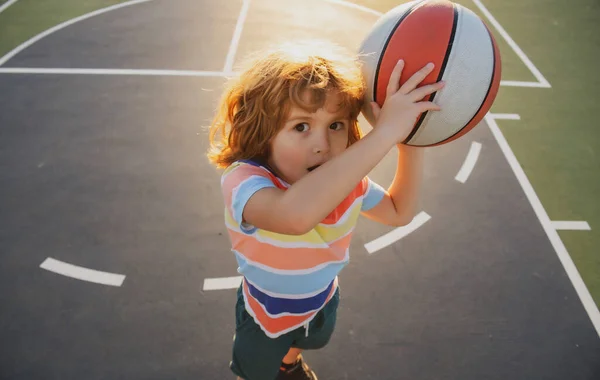 Mały chłopiec grający w koszykówkę z koszykówką. Szkoła koszykówki. — Zdjęcie stockowe