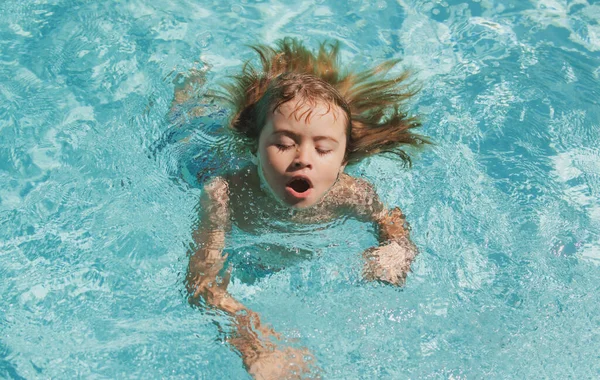 Niño en la piscina. Boy práctica natación. — Foto de Stock