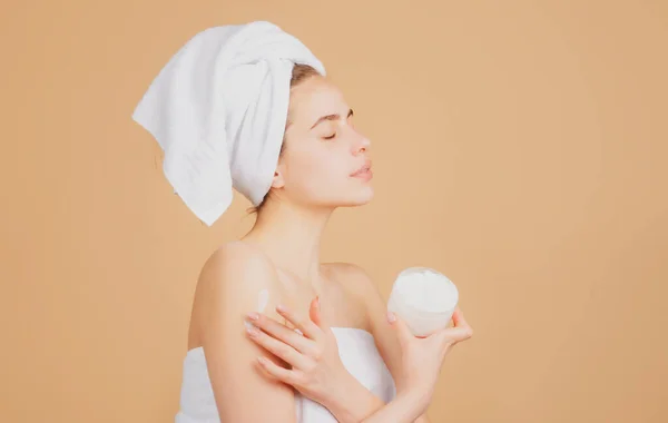 Retrato de cara de belleza. Terapia de spa, hermosa mujer en toalla con productos cosméticos. —  Fotos de Stock