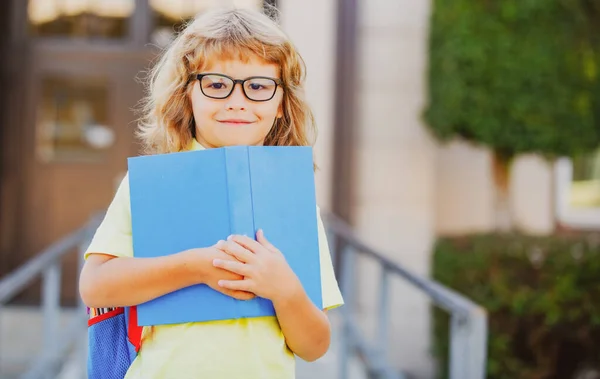 Возбужденный школьник с книгой в школе. — стоковое фото