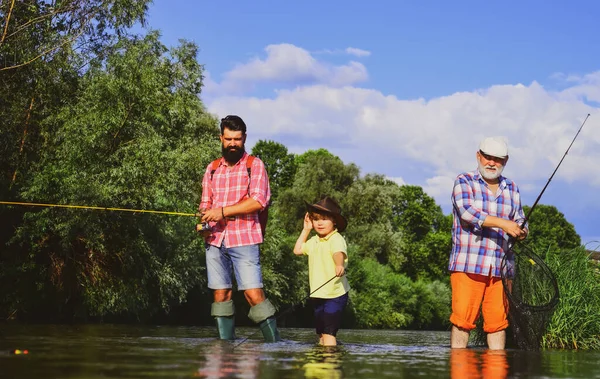 钓鱼。小男孩和他的父亲和祖父一起在湖上钓鱼。爷爷和爸爸带着可爱的孩子在钓鱼.飞鱼。14.业余活动和体育活动。男性多代家庭. — 图库照片