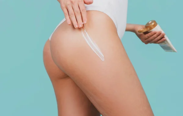 Cream on sexy woman buttocks with clean soft skin. Applying moisturizer cream on sensual butt. Cellulite or anti cellulite treatment. Body care and spa salon concept. — Foto Stock