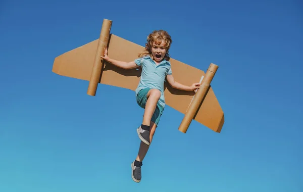 幸せな子供ジャンプや夏の空の背景におもちゃの翼で遊んでいます。子供の成功、指導者と勝者の概念. — ストック写真