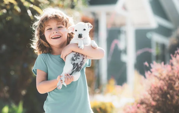 Kind wandelen met een hond buiten. Leuke kinder knuffel puppy. — Stockfoto