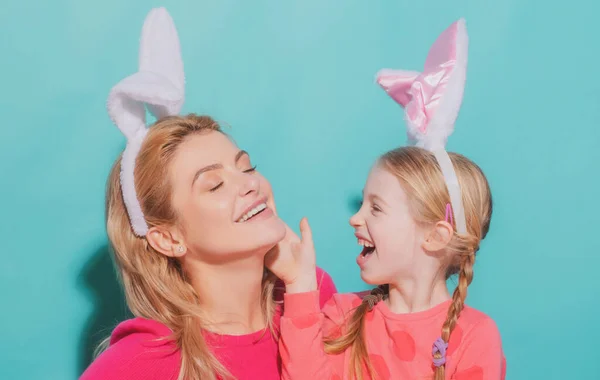 Mãe feliz e filha criança celebrando a Páscoa. Menina bonito com cara engraçada em orelhas de coelho rindo, sorrindo e se divertindo. — Fotografia de Stock