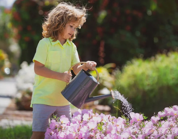 Cute little boy child watering flowers with watering can. Kids Gardening. — Stock Photo, Image