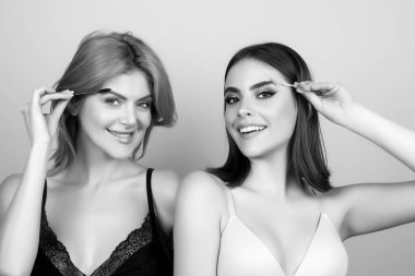 Kaşlarını fırçalayan güzel bir kadın. Makyaj fırçayla kaşlarını tarar. Profesyonel makyaj ve kozmetoloji yüz bakımı.