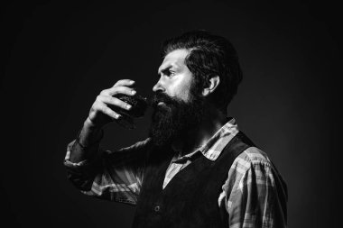 Sarhoş ya da iş adamı siyah arka planda viski içer. Alkollü içkiye bağımlı olmak. Kendine güvenen, iyi giyimli, bir bardak viskisi olan adam..