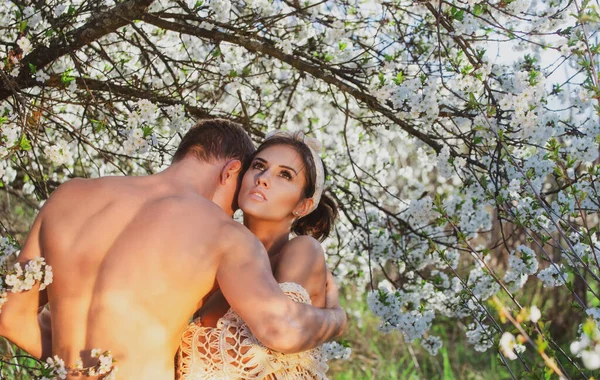 Pareja sensual enamorada. Amantes de la primavera en el árbol de flores. —  Fotos de Stock