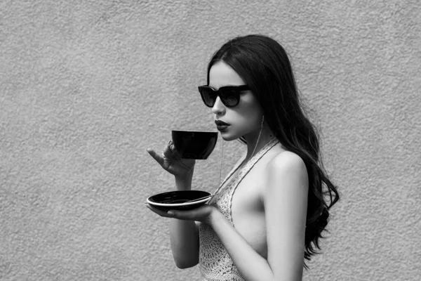 Mooi meisje met een stijlvolle zonnebril en donkere bessen lippenstift met een pauze. Luxe leven van beroemdheid vrouw. Modieus prachtig uitziende mooie meisje met een kopje koffie. — Stockfoto