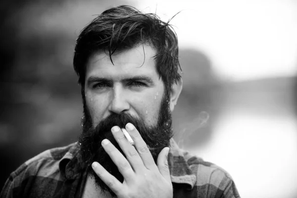 Dışarıda sigara içen sakallı bir adam. Kötü alışkanlık, sigara bağımlılığı. — Stok fotoğraf