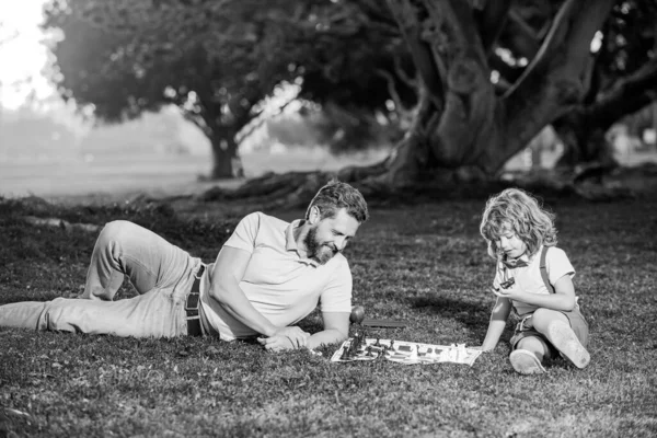 Счастливой семьи на открытом воздухе. Отец и сын играют в шахматы. — стоковое фото