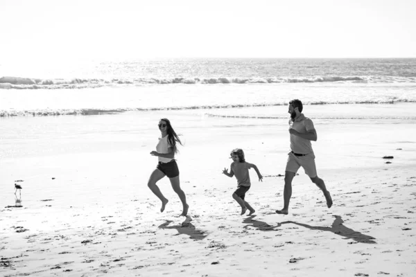 Padre, madre e hijo corren en la playa. Concepto estilo de vida familiar saludable. Vacaciones de verano en el mar. Estilo de vida saludable. —  Fotos de Stock