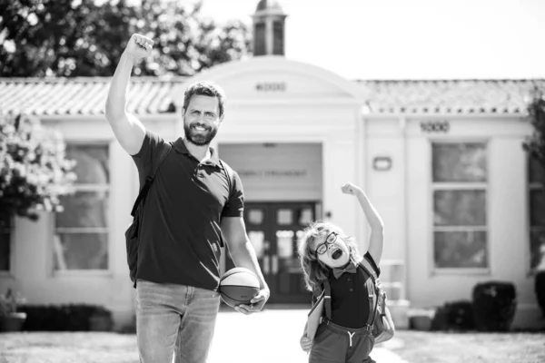 Vater und Sohn laufen mit Vater nach der Rückkehr von der Schule. Schule, Familie, Bildung und Outdoor-Konzept, zurück zur Schule und glückliche Zeit. — Stockfoto