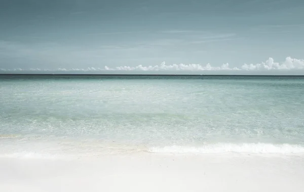 Suave ola azul del océano en la playa de arena limpia. — Foto de Stock