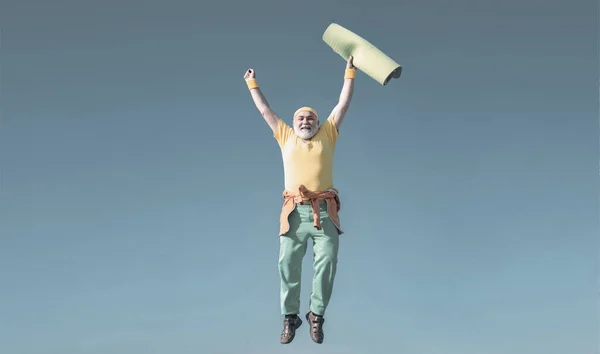 Sénior divertido saltando. Viejo saltando sobre el fondo azul del cielo. Concepto de retiro de libertad. Concepto de yoga. — Foto de Stock