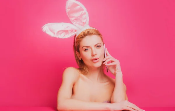 Mujer de Pascua con orejas de conejo hablando por teléfono. —  Fotos de Stock