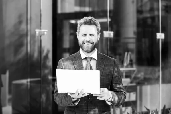 Портрет счастливого улыбающегося зрелого бизнесмена, стоящего вне офиса. — стоковое фото