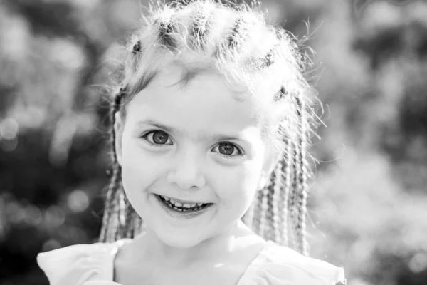 Mädchen lächeln mit Frisur-Dreadlocks. Kind mit modischem Haar im Freien. Glückliches Kind draußen. — Stockfoto