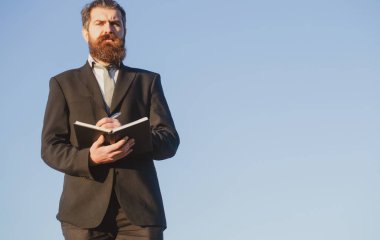 Gökyüzündeki iş adamı. Sakallı neşeli mali danışmanın bir fikri var. Belge, not defteri ve kalemle birlikte dizini tutan yönetici.