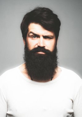 Kendine güvenen ciddi bir adamın portresi sakalı ve bıyığı var, ciddi ve izole görünüyor. Stüdyodaki hippi adam modelleri. İş adamı düşüncesi. Sakallı, şık saçlı, yakışıklı bir erkek..