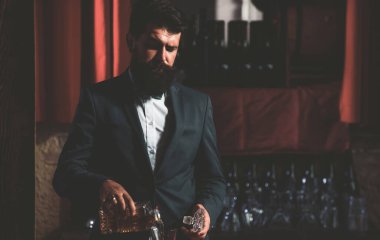 Barmen viski bardağına brendi dolduruyor. Alkol iç..