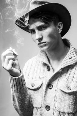 Sigara içen bir delikanlıyı yakından çek. Purolu adam. Yakışıklı adam kovboy şapkası takıyor..