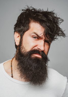 Erkek saç kesimi, modern saç stili. Uzun saçlı erkek modelin yakın portresi. Sağlık ve saç bakımı konsepti. Sakallı hippi.