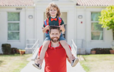 Baba oğul okul parkında yürüyor. Arkadaş canlısı aile kavramı.