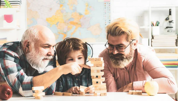 Felice uomo concetto di famiglia ridere e divertirsi insieme. Nonno guardando figlio e nipote giocare a gioco da tavolo a casa. — Foto Stock