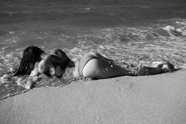 Ελκυστική Αφροαμερικανή γυναίκα με τέλειο σώμα που χαλαρώνει στην παραλία με σέξι μαγιό. Ηλιόλουστη μέρα διακοπών. — Φωτογραφία Αρχείου