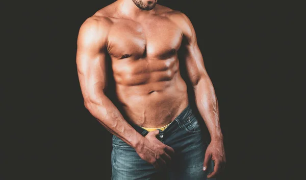 El tipo se desnuda los pantalones. Torso sexy de un hombre musculoso. Hombre musculoso guapo con seis abdominales paquete. — Foto de Stock