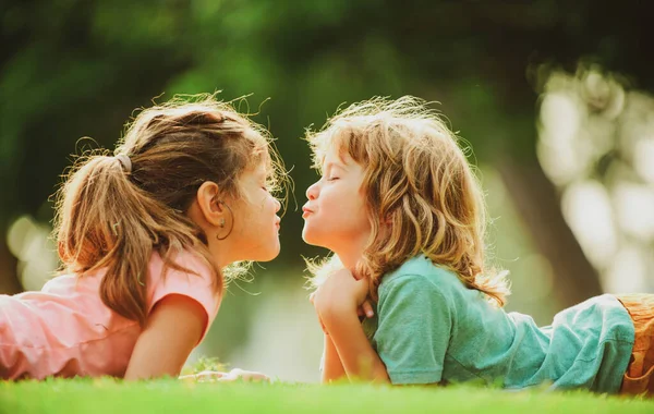 Kinderen relaties. Leuke liefde. Kleine kinderen zoenen buiten in het park. — Stockfoto