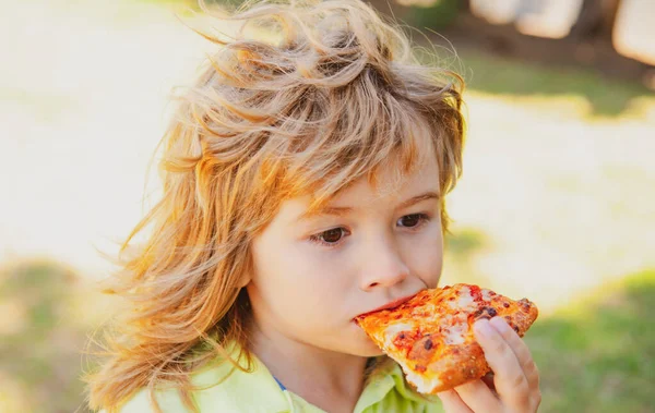 Ragazzo che mangia pizza all'aperto. Pizza il miglior cibo. Carino bambino mangiare pizza. — Foto Stock