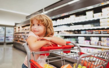 Alışveriş arabalı çocuk marketten ya da süpermarketten yiyecek alıyor..