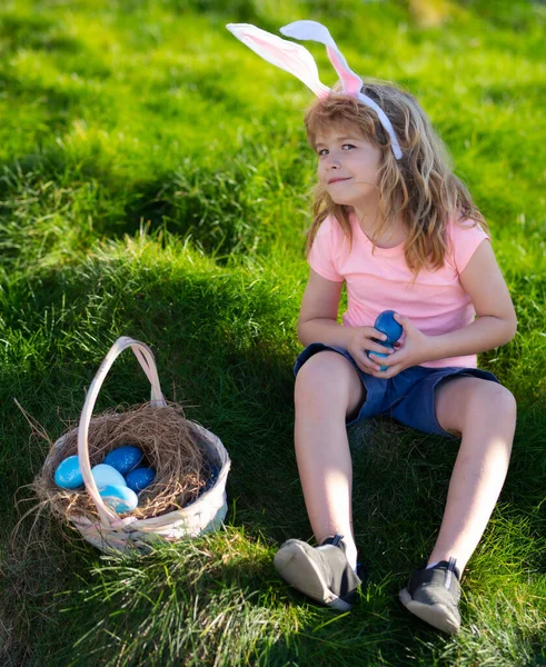 Paskalya tavşanı şirin yüzlü çocuk. Çocuklar paskalya yumurtası avlıyor. Tavşan kostümlü çocuk dışarıda oynuyor.. — Stok fotoğraf