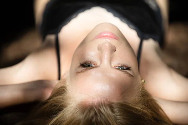 Blonde girl closeup face. Sensual woman with light on a black background. Beautiful female face in the darkness. Tender and seductive look. Fashion art studio portrait. — Stock Photo, Image