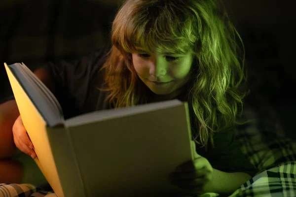 Barn läser böcker. Ungar lägger sig, pojkar läser en bok i sängen. Barnets utveckling. Smart pojke med barn. — Stockfoto