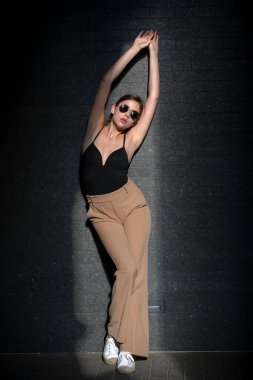 Stüdyo arka planında güzel elbiseli güzel bir genç kadının moda fotoğrafı. Moda mankeni, moda elbiseli zarif bir kadın stüdyoda poz veriyor..